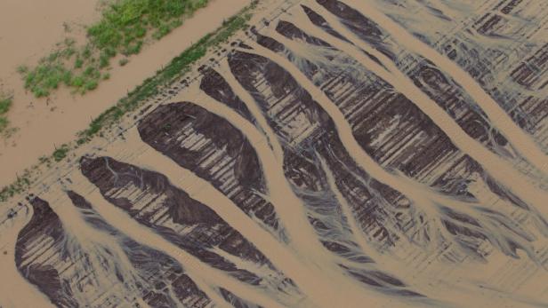 Ein überschwemmtes Feld aus der Vogelperspektive zeigt Erosionsspuren.