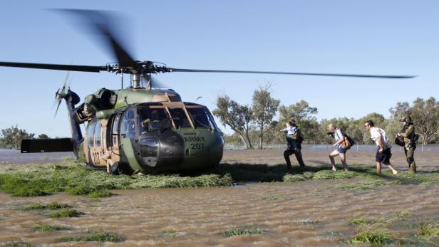 Ein Militärhubschrauber evakuiert Menschen aus einem überschwemmten Gebiet.