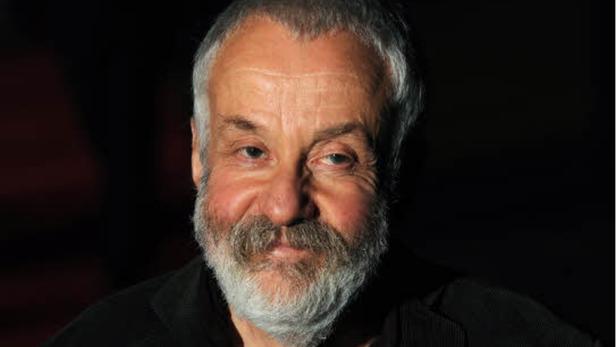 Porträt von Götz George mit grauem Bart vor dunklem Hintergrund.