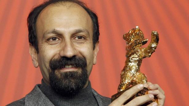 Asghar Farhadi hält eine goldene Bären-Trophäe.