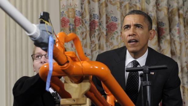 Barack Obama betrachtet eine Apparatur aus Rohren und Ventilen.