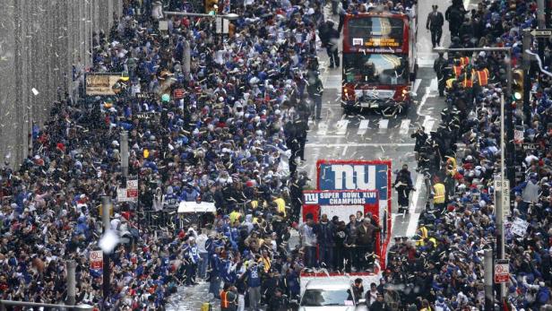 Eine Parade der New York Giants inmitten einer jubelnden Menschenmenge in New York City.