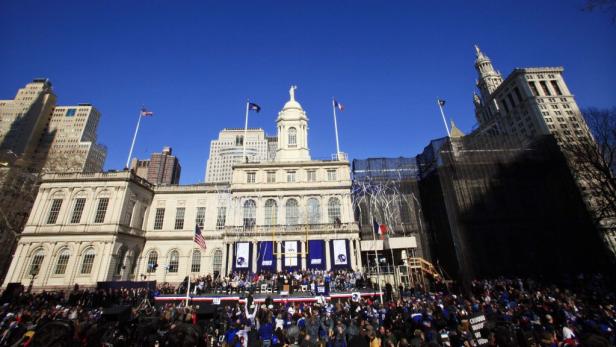 Eine Menschenmenge versammelt sich vor dem Rathaus von New York City, geschmückt mit „Giants“-Bannern.