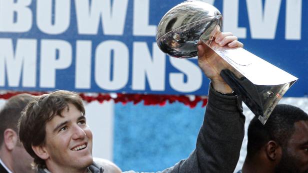 Eli Manning hält die Vince Lombardi Trophy nach dem Gewinn des Super Bowl XLVI hoch.