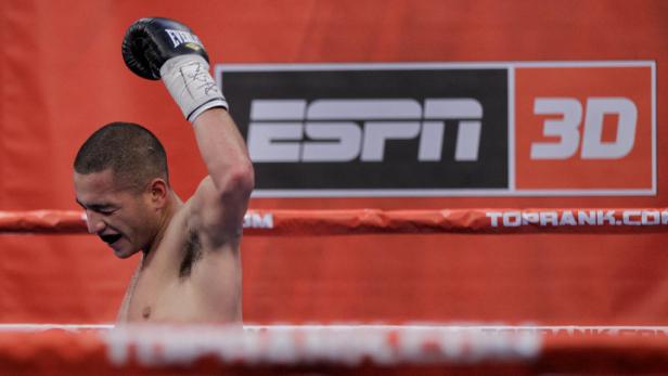 Ein Boxer feiert seinen Sieg im Ring vor einem ESPN 3D-Logo.