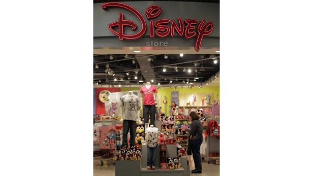 Ein Blick in einen Disney Store mit Kleidung, Plüschtieren und einer Kundin.