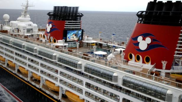 Ein Blick auf ein Kreuzfahrtschiff von Disney mit einem großen Bildschirm an Deck.