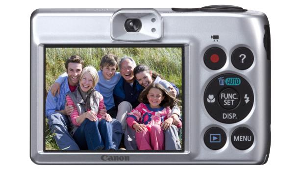 Auf dem Display einer silbernen Canon-Kamera ist eine glückliche Familie zu sehen.