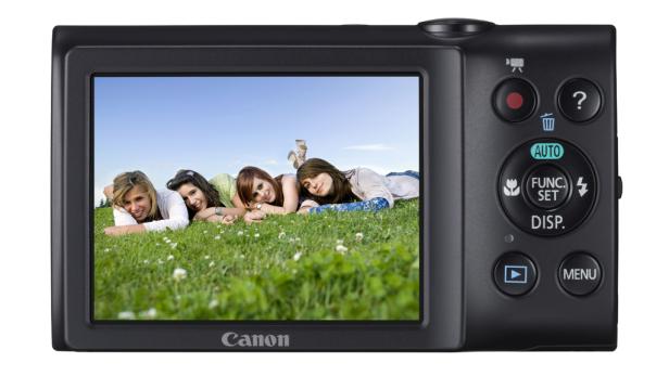 Auf dem Display einer Kamera liegen vier junge Frauen im Gras.