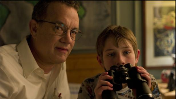 Tom Hanks und ein Kind schauen durch ein Fernglas.