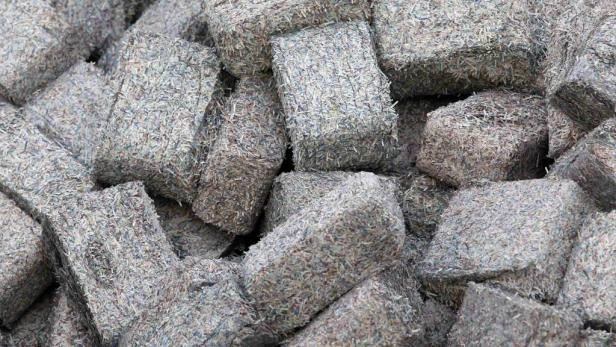 Ein Haufen gepresster, rechteckiger Blöcke aus recyceltem Material.