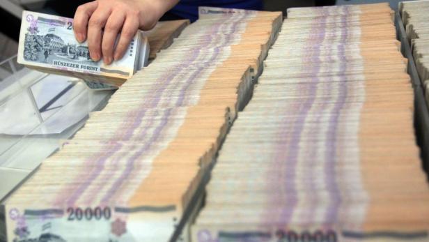 Eine Hand hält einen Stapel ungarischer 20.000 Forint Banknoten.