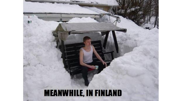 Ein Mann sitzt auf einer Schaukel, umgeben von hohen Schneemassen.