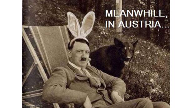 Adolf Hitler sitzt mit Hasenohren und einem Hund im Garten.