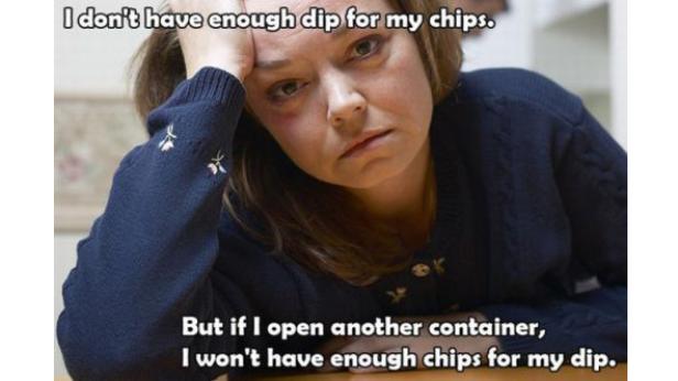 Eine Frau blickt frustriert, weil sie nicht genug Dip für ihre Chips hat.