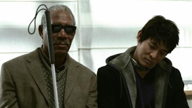 Morgan Freeman als blinder Mann mit Stock neben einem jüngeren Mann.