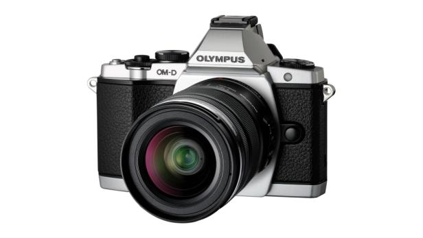 Eine silberne Olympus OM-D Kamera mit einem schwarzen Objektiv vor einem weißen Hintergrund.