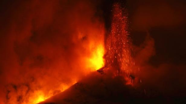 Ein Vulkan bricht aus und speit Lava und Asche in den Himmel.