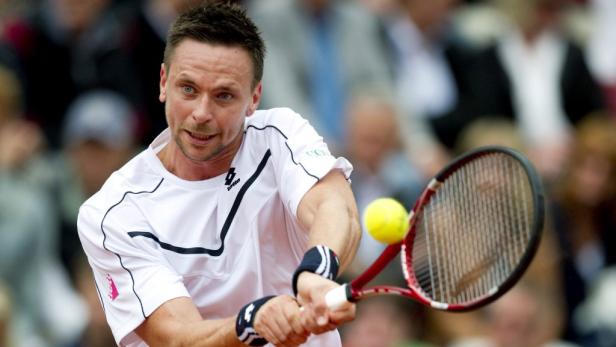 Ein Tennisspieler schlägt einen gelben Tennisball mit seinem Schläger.