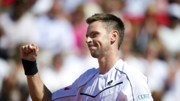 Ein Tennisspieler ballt die Faust und freut sich über einen Sieg.