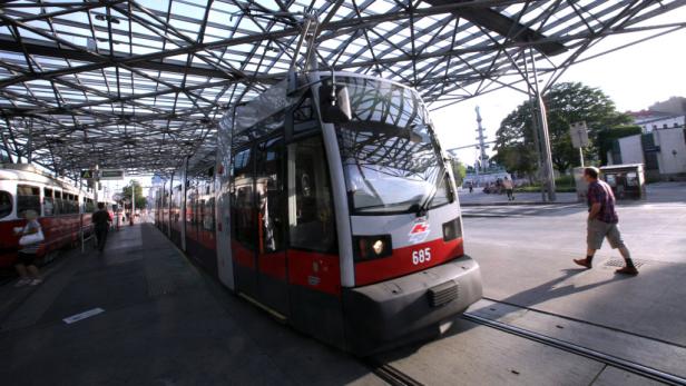 Eine moderne Straßenbahn der Wiener Linien an einer Haltestelle.
