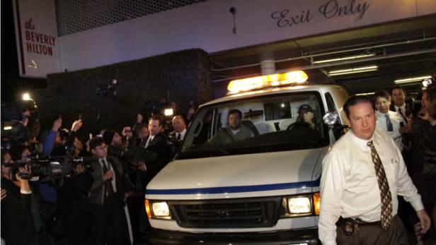 Ein weißer Lieferwagen mit Blaulicht vor dem Beverly Hilton Hotel wird von Reportern umringt.