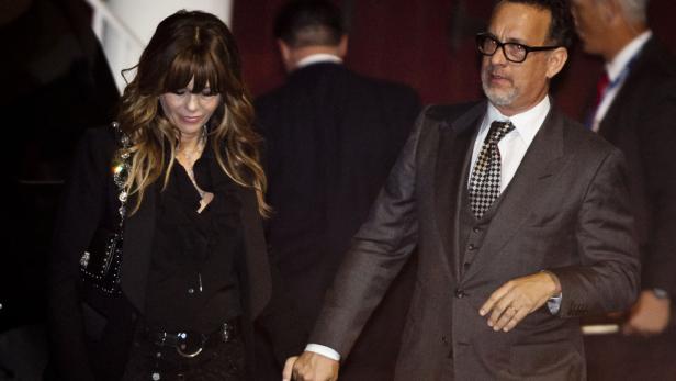 Tom Hanks führt eine Frau, möglicherweise seine Frau Rita Wilson, an der Hand.