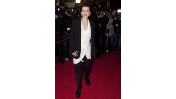 Juliette Binoche auf dem roten Teppich, umgeben von Fotografen.