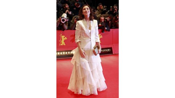 Eine Frau in einem weißen Hosenanzug auf dem roten Teppich der Berlinale.