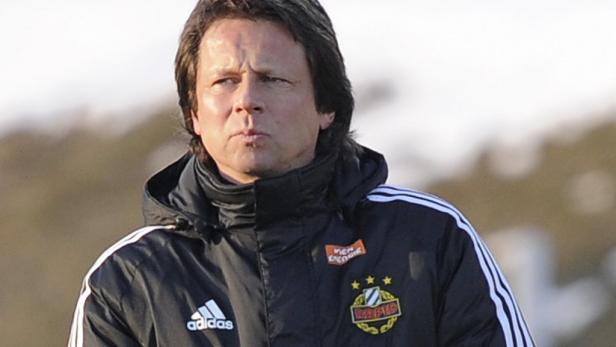 Ein Mann in einer Adidas-Jacke mit dem Logo des SK Rapid Wien.