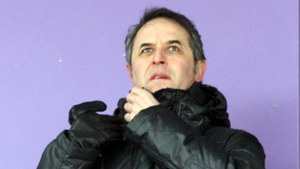 Ein Mann mit Handschuhen und Winterjacke vor einem lila Hintergrund.