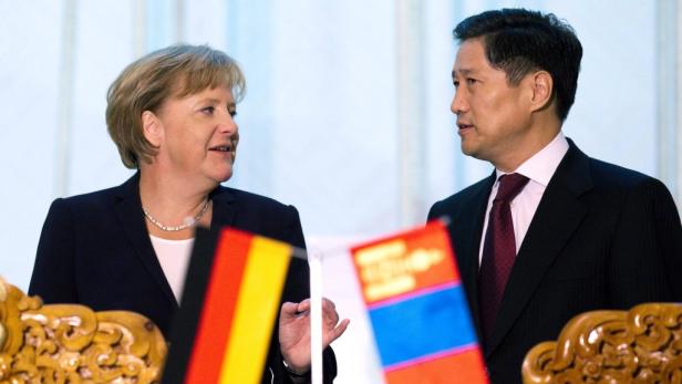 Angela Merkel trifft einen mongolischen Würdenträger.