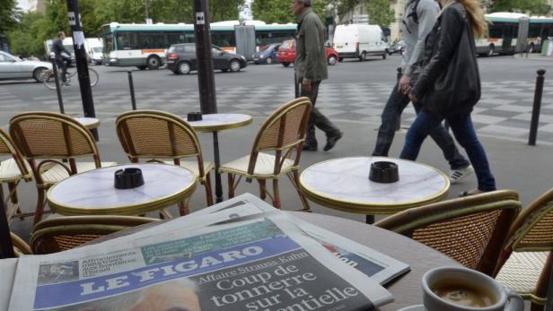 Ein Straßencafé in Paris mit der Zeitung „Le Figaro“ auf dem Tisch.