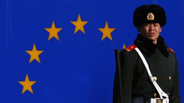 Ein chinesischer Soldat steht vor der Flagge der Europäischen Union.