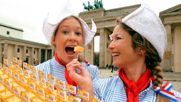 Zwei Frauen in traditioneller niederländischer Tracht bieten Käse vor dem Brandenburger Tor an.