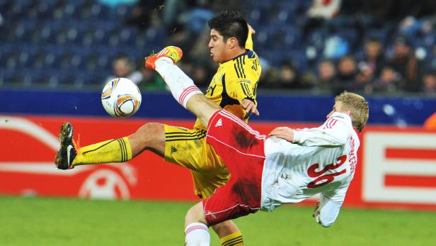 Zwei Fußballspieler kämpfen um den Ball während eines Spiels.