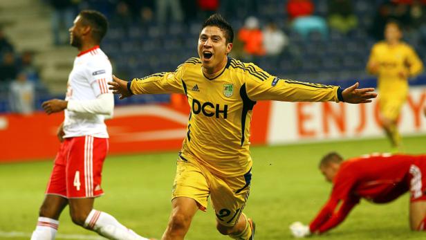 Ein Fußballspieler in gelber Uniform jubelt auf dem Spielfeld.