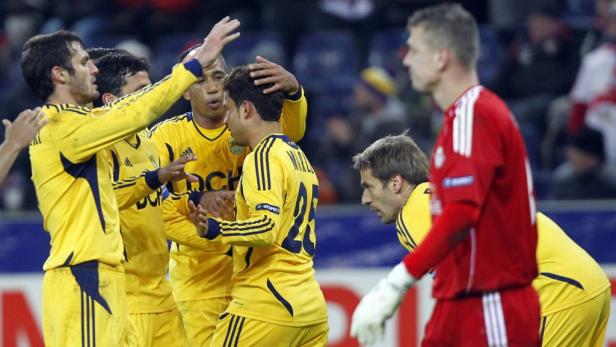 Fußballspieler in gelben Trikots feiern auf dem Spielfeld.