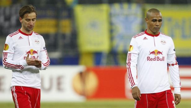 Zwei Fußballspieler von RB Leipzig in ihren Trikots auf dem Spielfeld.