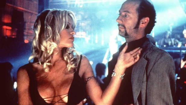 Pamela Anderson und ein Mann in einem Nachtclub.
