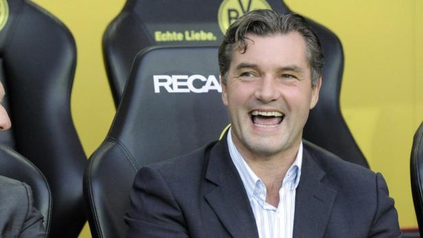 Michael Zorc lacht auf der Bank von Borussia Dortmund.