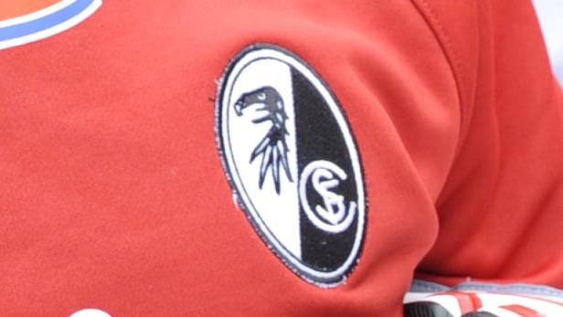 Das Logo des SC Freiburg auf einem roten Trikot.