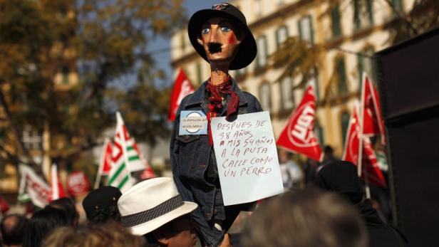 Eine Puppe mit Schildern protestiert auf einer Kundgebung gegen die Zerstörung des Arbeitsrechts.