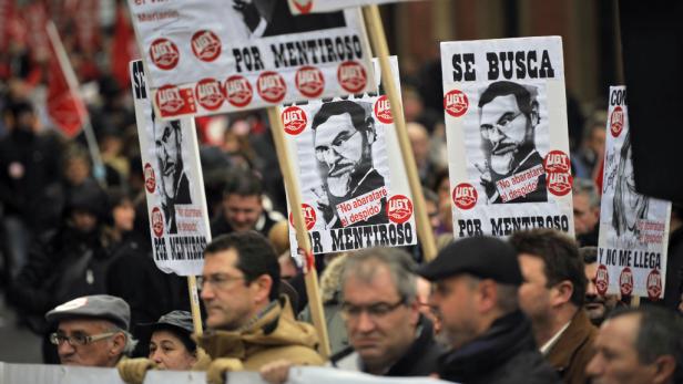 Demonstranten halten Schilder mit dem Slogan „Por Mentiroso“ (Für Lügner) hoch.