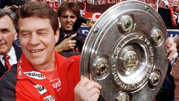 Ein Mann hält die Meisterschale der Fußball-Bundesliga in seinen Händen.