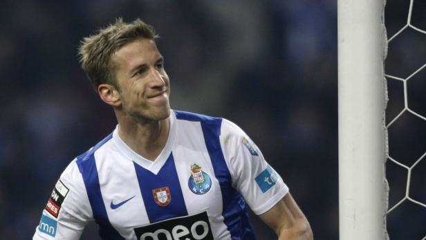 Ein Fußballspieler des FC Porto lächelt neben einem Torpfosten.