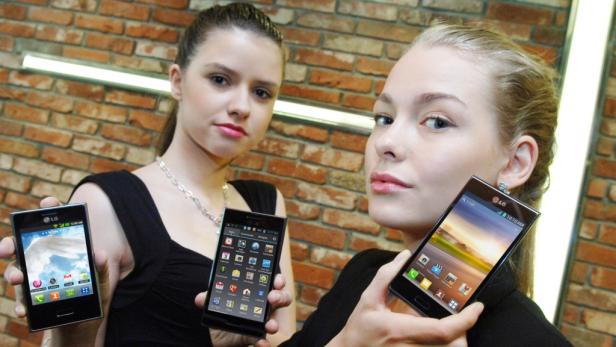 Zwei Frauen präsentieren verschiedene Modelle von LG Smartphones.