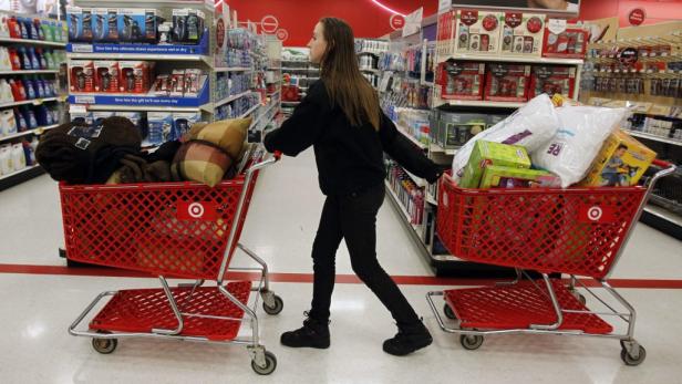 Eine Frau schiebt zwei volle Einkaufswagen in einem Target-Markt.