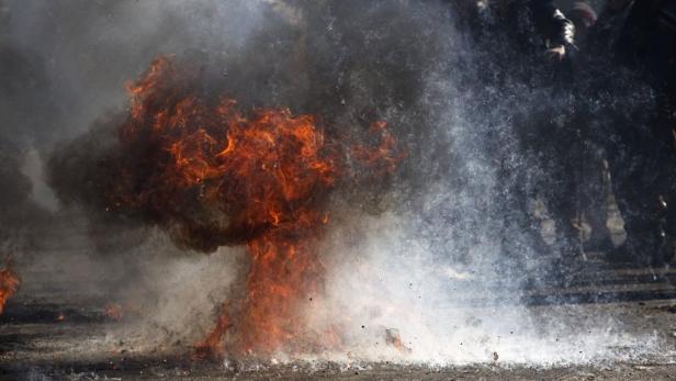 Flammen und Rauch steigen von einem brennenden Objekt auf.