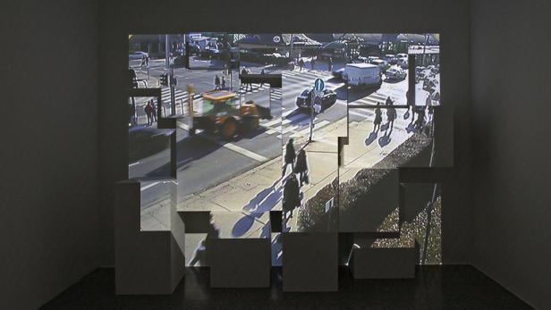 Eine Videoinstallation zeigt eine belebte Straßenkreuzung auf mehreren Würfeln.